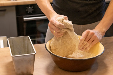 Hands kneading dough in a bowl