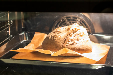 Shot of the freshly baked loaf of home made rye bread in the ovenの写真素材