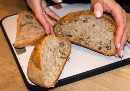 Woman holds cuts of freshly baked of home made rye breadの写真素材