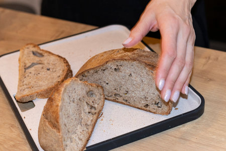 Woman holds cuts of freshly baked of home made rye breadの写真素材
