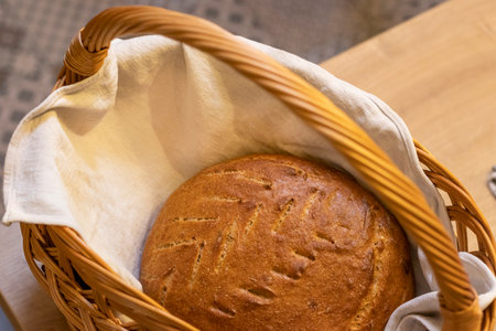 Shot of the freshly baked loaf of home made rye bread on the linen cloth in the wicker basketの写真素材