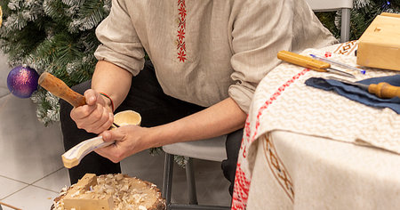 Man in traditional belarusian outfit makes souvenirs by birch bark weavingの写真素材