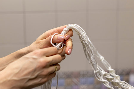 Woman weaving macrame flowerpot.の写真素材