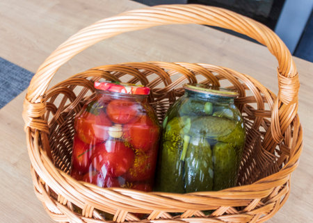Jars with different types of pickles and preserves in a wicker basketの写真素材