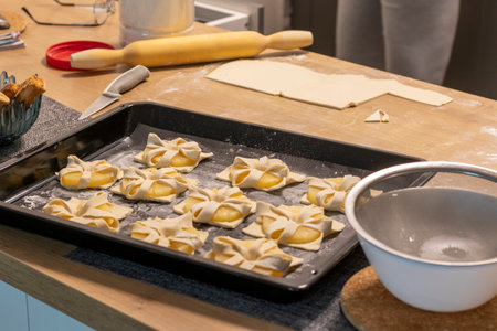 Shot of pineapple wedges wrapped in puff pastry on the baking tray on the kitchen counterの写真素材