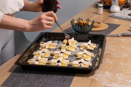 A woman places a cherry on the top of the puff pastry with pineapple wedges wrapped.の写真素材