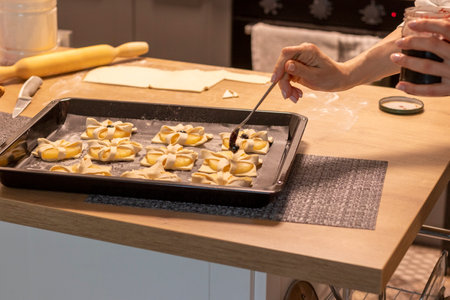 A woman places a cherry on top of puff pastry with pineapple wedges wrapped.の写真素材