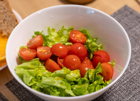 Bowl with cherry tomatoes and lettuce leavesの写真素材