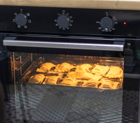 Puff pastries with cottage cheese filling baking in the ovenの写真素材