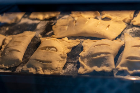 Puff pastries with cottage cheese filling baking in the ovenの写真素材