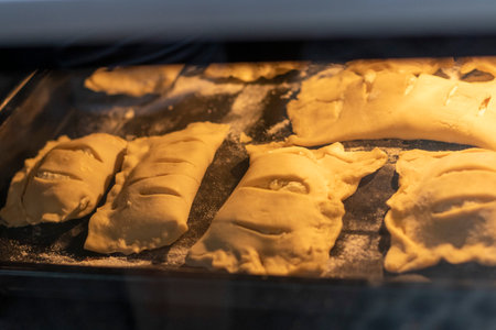 Puff pastries with cottage cheese filling baking in the ovenの写真素材