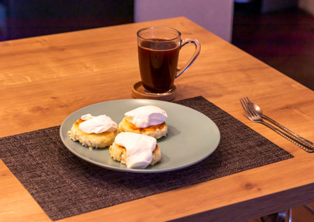 Traditional russian breakfast cheese cakes or syrniki made of cottage cheese on the plate next to cup of cofeeの写真素材