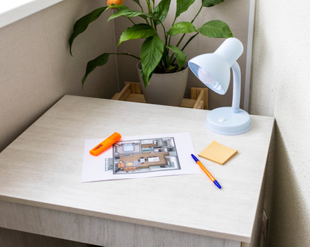 Layout of the small, furnished apartment printed on the sheet of paper placed on the deskの写真素材
