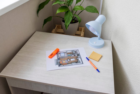 Layout of the small, furnished apartment printed on the sheet of paper placed on the deskの写真素材