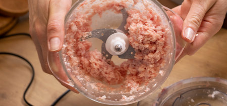 Just ground meat mince in the glass bawl of the electrical chopper on the kitchen counter topの写真素材