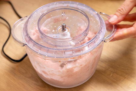 Just ground meat mince in the glass bawl of the electrical chopper on the kitchen counter topの写真素材