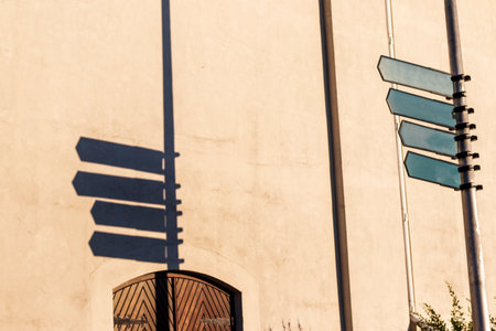 Old style direction signs casting shadow on near by wall