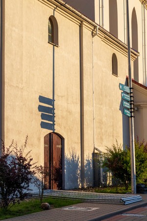 Old style direction signs casting shadow on near by wallの写真素材