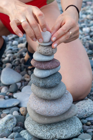 Woman making cairn on the beach