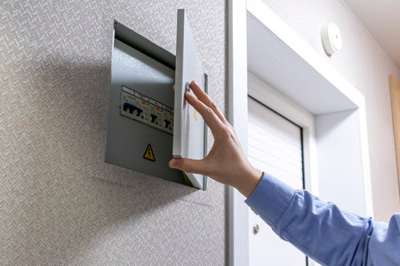 A man checks an indoor circuit breaker box