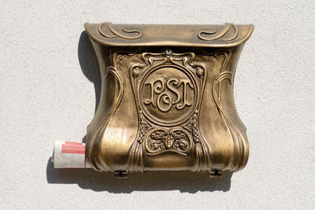 old decorative mailbox on wall with blank newspaperの写真素材