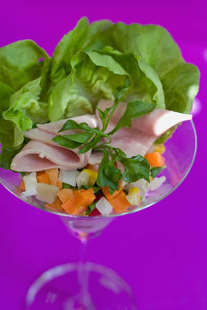 Ham cocktail in a martini glass, with cos lettuce and seafood cocktail sauce on violet background with light effect. click for more photo of international food and baverageの写真素材