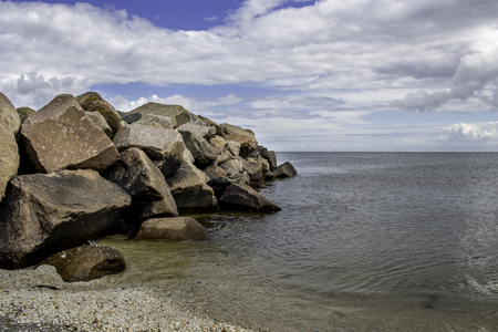 Large rocks in the water on the beach on a nice summers dayの写真素材