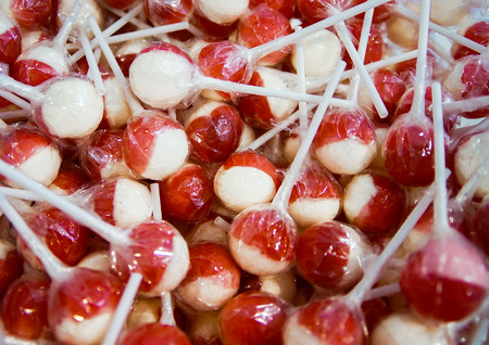 Sweet sugar candy in pile at candy shop. Red and white color.