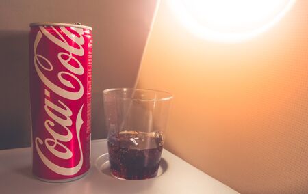 Samuthprakan, Thailand - May 8, 2017 : Coca Cola can with half glass of Coca Cola drink on airplane tray.のeditorial素材
