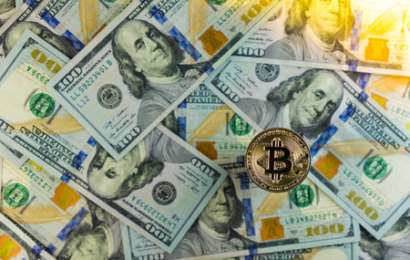 Golden Bitcoin on Dollar bills background, with copy space.の写真素材