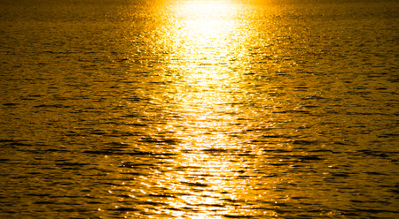 Abstract background : Sunlight reflection on moving water surface, during sunset time.