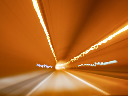 Abstract Background : Light painting in random concept. Trail of light as of long speed shutter and shaking camera in random movement during car driving in tunnel. Blurred background concept.の写真素材