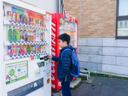 Otaru, Japan - October 19, 2017 : A boy selecting drink from automatic vending machine, at Otaru, Hokkaido, Japan.のeditorial素材