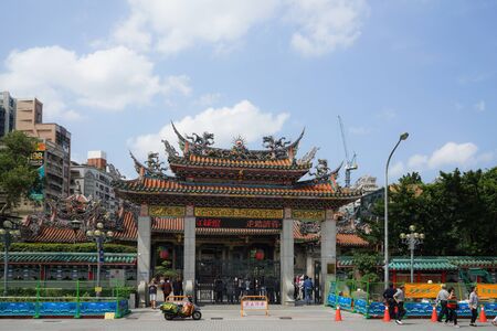 Taipei, Taiwan - April 19, 2018 : People walking and traffic in front of the gate of LONGSHAN Temple.のeditorial素材