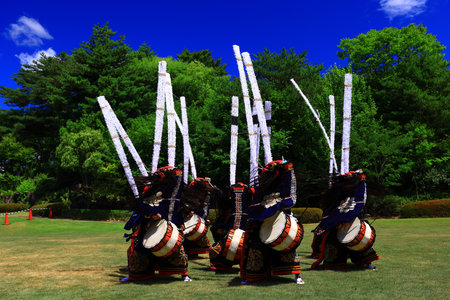 Unidentified performers are engaging in a traditional performance with drums and elaborate costumes.の写真素材