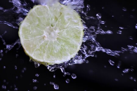 water splash with lemon in a black backgroundの写真素材