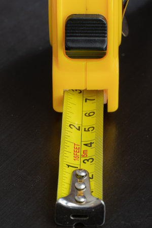 steel metal maesuring tape yelow color macro in a table