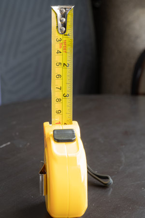 steel metal maesuring tape yelow color macro in a table