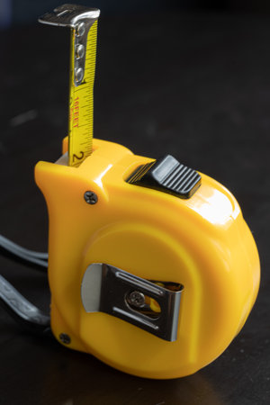 steel metal maesuring tape yelow color macro in a table