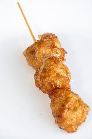 CLose-up view of fried wanton in a white color plate with stick on itの写真素材
