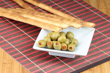 Italian Grissini bread stick and olives with red pepper.の写真素材