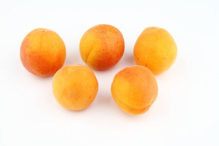 Five fresh apricots isolated on white background.の写真素材
