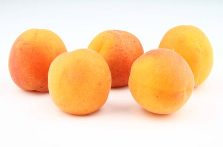 Five fresh apricots isolated on white background.の写真素材