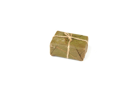 Handmade soap packaged in banana leaf on white background.の写真素材