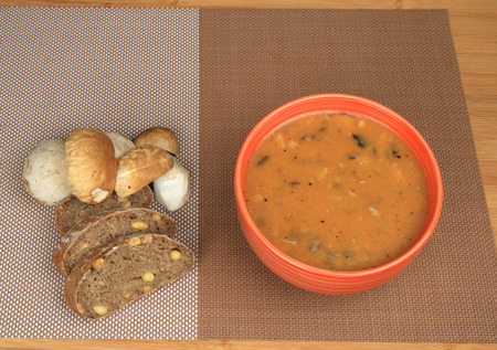 Goulash mushrooms in bowl on wooden table with fresh mushrooms sliced bread.の写真素材
