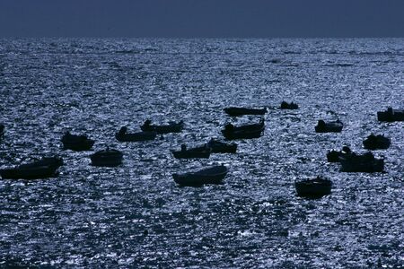 Fishing boats illuminated by the moonlight in Cadiz, Spainの写真素材