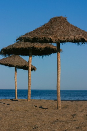 Straw umbrellas on a beautiful tropical beachの写真素材