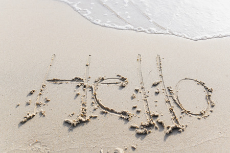 The text Hello morning Write on the sand beach by the sea, used in greeting