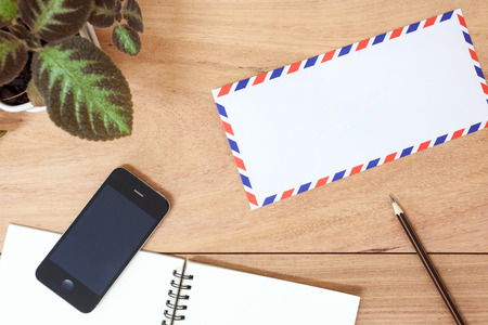 Office table with notepad, telephone and envelope. View from above with copy spaceの写真素材