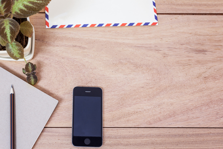 Office table with notepad, telephone and envelope. View from above with copy spaceの写真素材